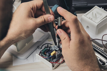 Repair of electronic devices, tin soldering parts. Hands of man holding screwdriver. Computer...