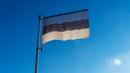 Estonian flag in front of blue sky with lens flare. Diplomacy concept. International relations.