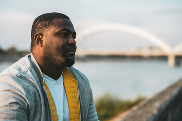 Depressed black man sitting outdoor.