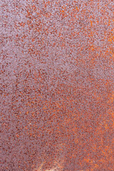 On an ancient iron wall, there is orange rust.