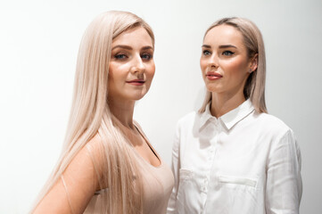 Two blonde women portrait in beauty salon