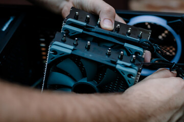 Case computer black fan close-up background. Upgrade or PC assembly concept. Technician installs computer cooling element. Technology concept background. Hardware components. 