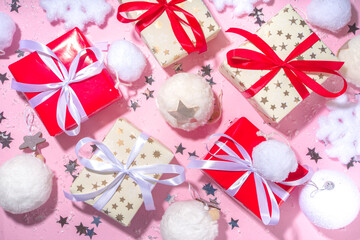 Fluffy Christmas concept. Festive Christmas background with fluffy decoration stuff, xmas ball, gift boxes, with artificial snow and shiny stars on pink color background copy space