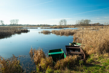 Fototapeta premium Anglers' boats on the shore of a calm lake