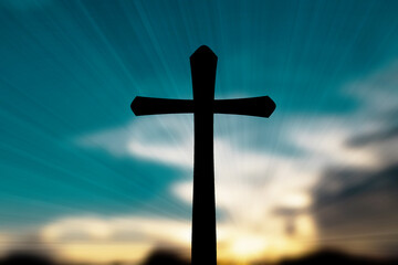 Silhouette of Christian cross on blur sunset background.