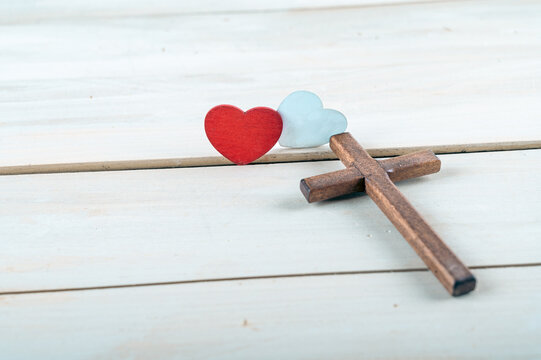 Cross and Two wooden red and white hearts on old background, GOD IS LOVE concept.