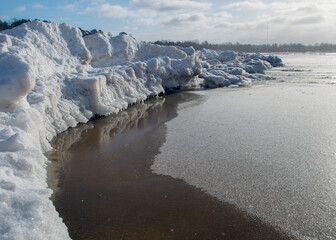 winter landscape by the sea, snowy, interesting ice shapes on the sea shore, dunes covered with a...