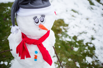 funny snowman on lawn made from first snow. winter fun. christmas background