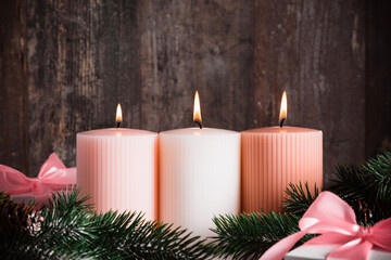 Christmas background, three burning candles, Christmas tree and gift on dark wood background