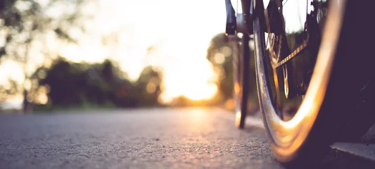 Fototapeten Rennrad auf einem schönen Straßensonnenuntergang geparkt, warmes Licht mit Kopierraum. © PIPAT