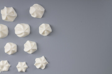 White whipped cream in the shape of a rose on a gray background © Olga