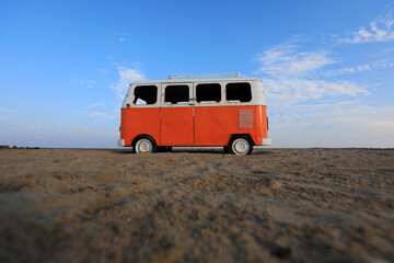 The red bus model is on the beach at a scenic spot