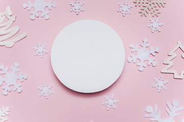 Christmas composition with white decorations on a pink background. Blank white paper circle shape. Christmas pattern. Flat lay, top view, copy space, mock up