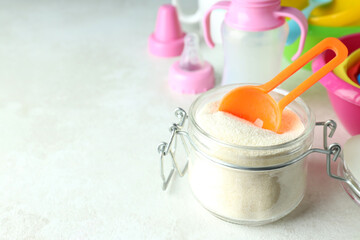 Concept of baby food with рowdered milk on white textured background