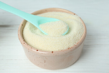Concept of baby food with рowdered milk on white wooden background