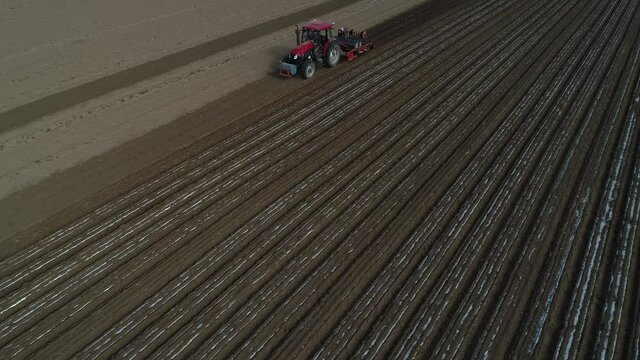 Farmers use planters to plant plastic coated peanuts on farms, North China