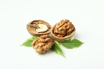 Fototapeta na wymiar Walnuts with nutshell and leaves on white background