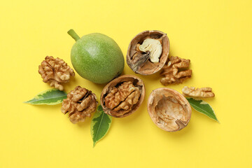 Walnuts with nut peel on yellow background