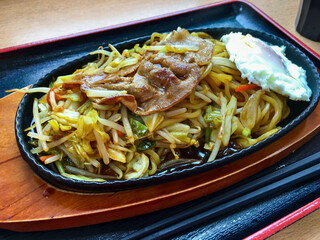 Closeup Japanese Yakisoba (fried noodle) with medamayaki (fried egg) plate. Yakisoba is a prepared by frying ramen-style wheat noodles with bite-sized pork and chopped vegetables