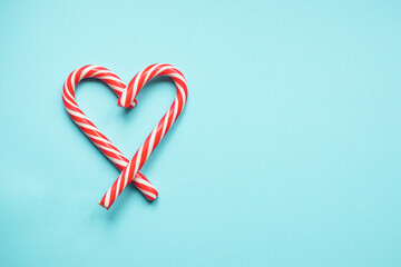 Christmas lollipops in the form of a heart on a blue background. Copy space