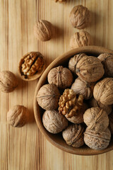 Walnuts in wooden bowl on wooden background