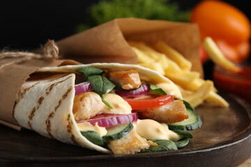 Delicious chicken shawarma on wooden board, closeup