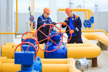 A uniformed worker opens a valve to control gases.