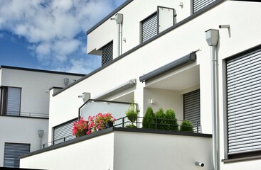 Moderne Betonbalkone mit beschichtetem Metall-Geländer und Attika-Blech als Mauerschutz an...