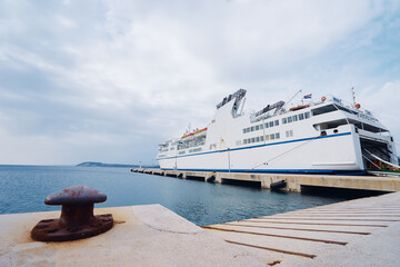 Ferryboat loading or unloading by a port pier. Concept of transportation and traveling.