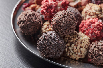Chocolate candies with, nuts and dried strawberries.