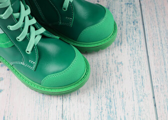 Green sneakers for a child on a wooden background, children's shoes, a copy of the space