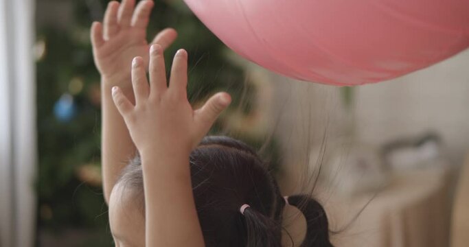 4K Slow motion Little Asian girl is learning about static electricity from rubber ring(pink) and hair standing up, child learning science concept.