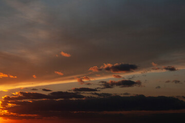 The red sun has disappeared below the horizon and high clouds cover the evening sky. Beautiful sunset.
