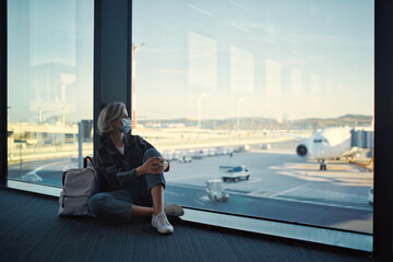 New normal and social distance concept. Young woman tourist wearing face mask during corona virus outbreak at airport.