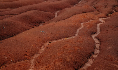 a red soil mound that makes a small river