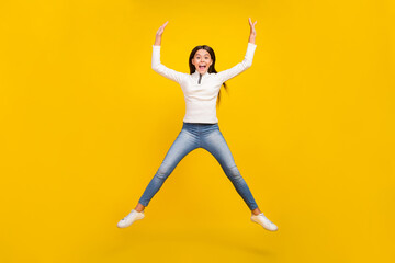 Fototapeta na wymiar Full length photo of cool brunette small girl jump wear sweater jeans sneakers isolated on yellow color background