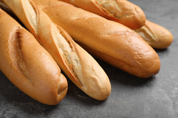 Different tasty baguettes on grey table, closeup