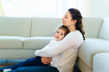 Mother with her daughter relaxing in living room at home