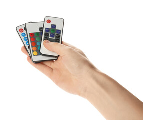 Woman holding remote controls on white background, closeup