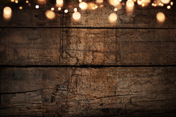 Iluminated old weathered wooden wall with festive golden bokeh lights. Background for christmas...