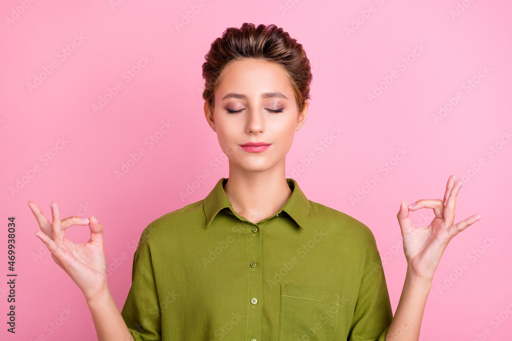 Wall mural Photo of pretty adorable young woman dressed green shirt closed eyes practicing yoga isolated pink color background