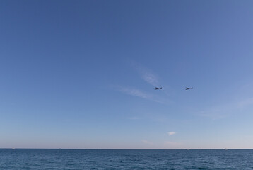 Military helicopters in the sky over the sea