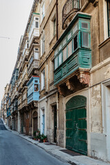 Fototapeta na wymiar Traditional colorful Maltese doors in Valletta. Front doors to houses from Malta. Blue green doors and wooden balcony. Maltese vintage apartment buildings.Popular travel destination. Entrance to house