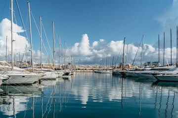 Luxury boats and yachts in harbor. Sunny summer day.Holiday high class lifestyle travel concept.Boat trip in Mediterranean.View of expensive sailing yachts at pier with water reflection.Marine dock