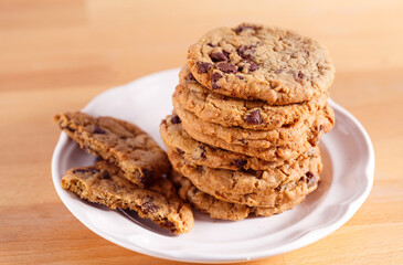 Stack of chocolate chip cookies in a white plate with copy space