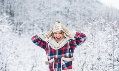 Fototapeta na wymiar Cheerful emotional girl having fun outdoors. Winter outfit. Woman wear warm accessories stand in snowy nature. Winter fashion collection. Winter admirer. Favorite season. Enjoy every snowflake
