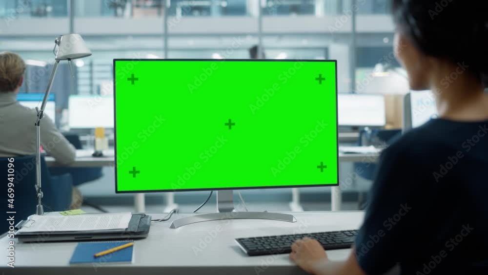 Poster Close Up Over the Shoulder Shot of a Businesswoman Working on Desktop Computer with Chroma Key Green Screen Mock Up Display. Digital Projects Manager Typing Data, Using Keyboard and Mouse.