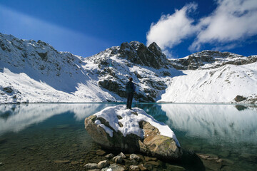 Tourist on the background of a mountain lake in the Caucasus Mountains, Arkhyz, Russia.