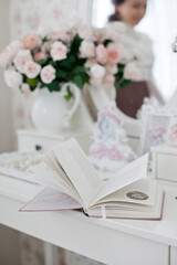 Vintage dressing table with pink roses and pearls jewelry and a book