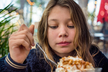 cute little girl enjoying a big cup of ice cream